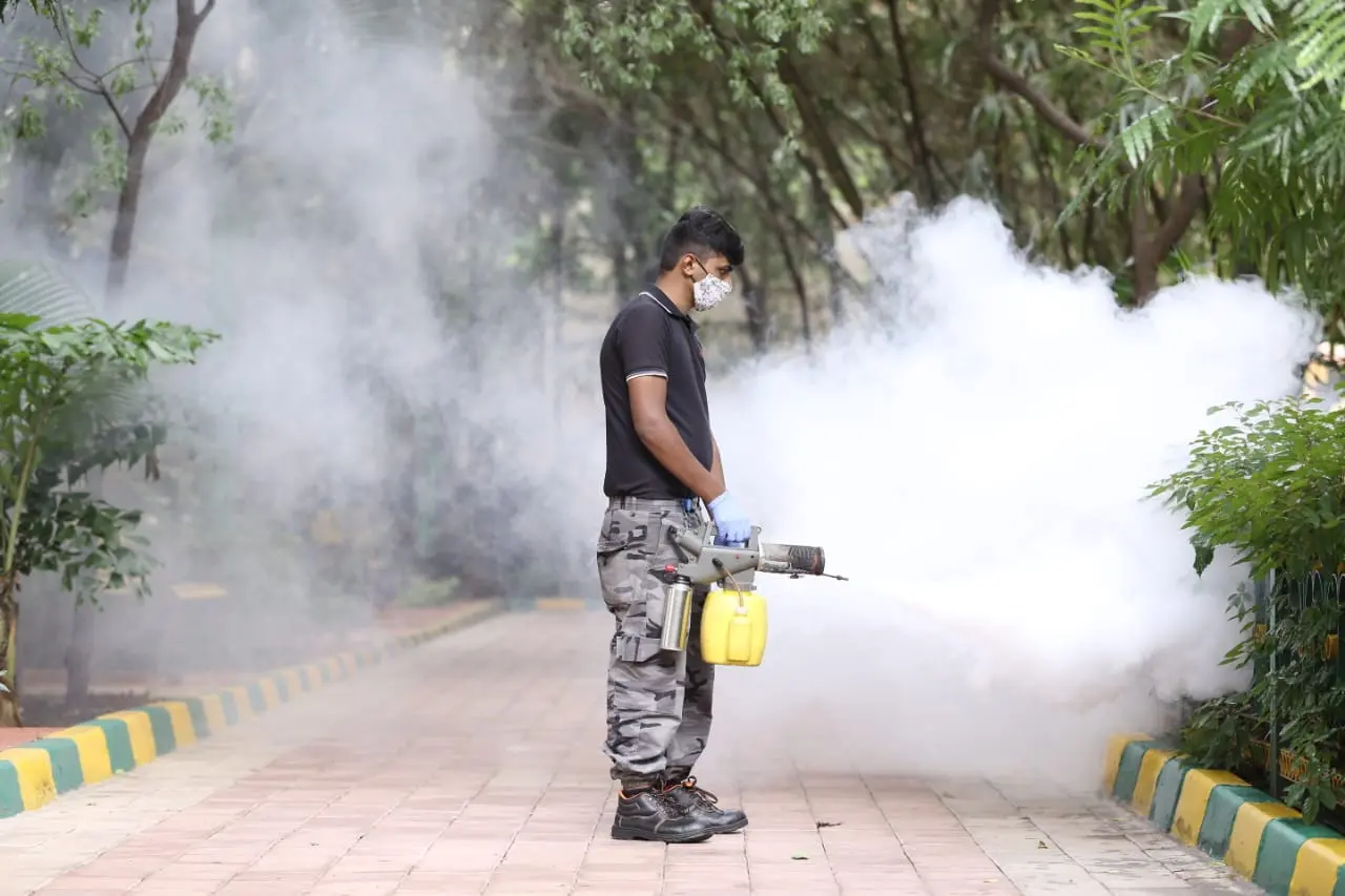 Certified technician performing an outdoor pest treatment