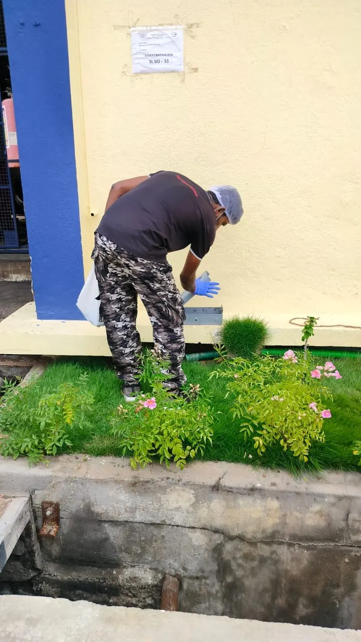 Technician servicing an outdoor rodent bait station